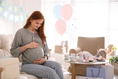 Photo of Happy pregnant woman in room decorated for baby shower party