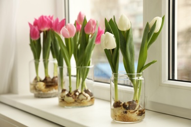 Photo of Beautiful tulips with bulbs on window sill indoors