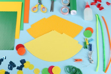Photo of Flat lay composition with different materials to create party hats on light blue background. Handmade decoration