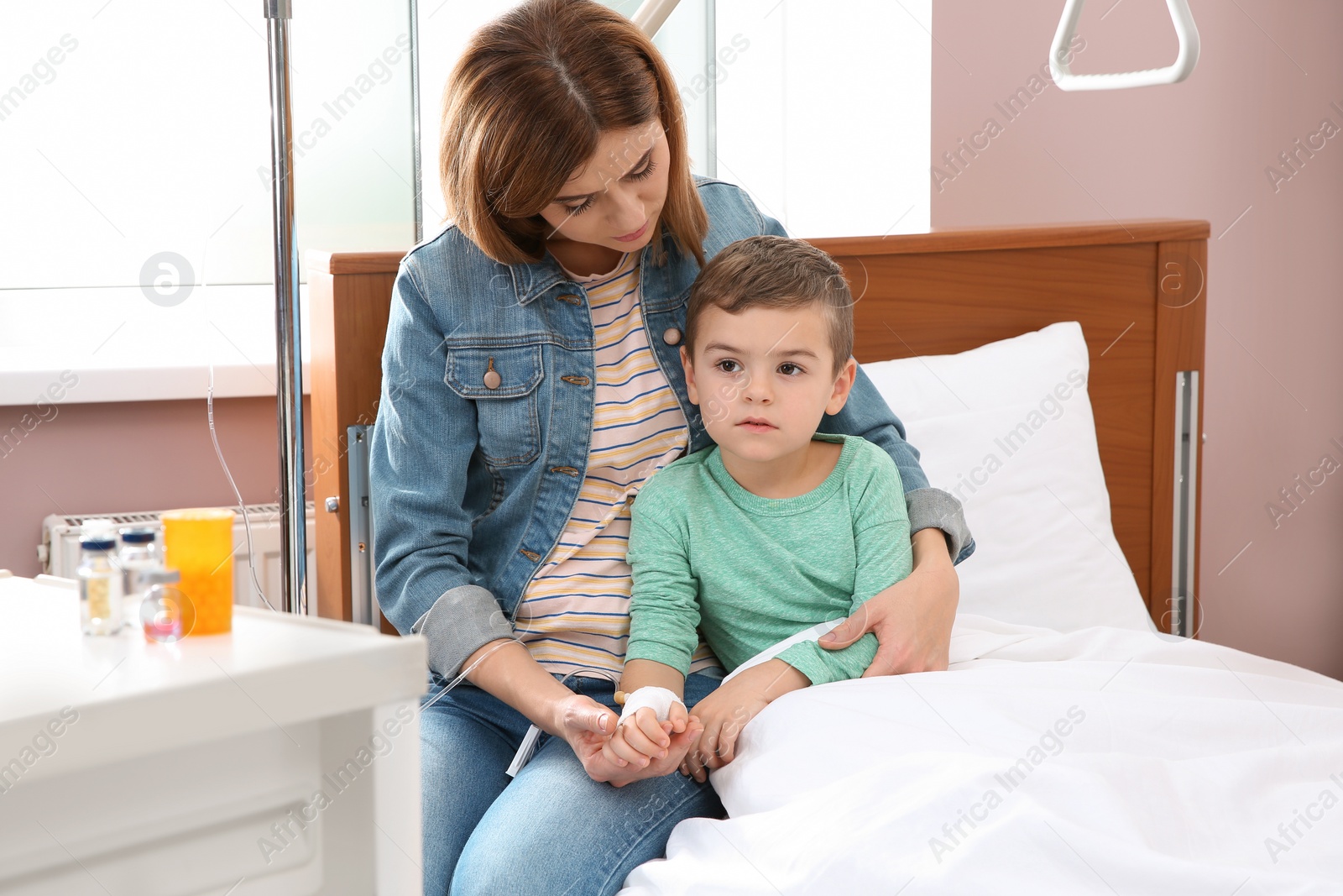 Photo of Woman visiting her little child with intravenous drip in hospital