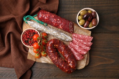 Different types of tasty sausages on wooden table, flat lay