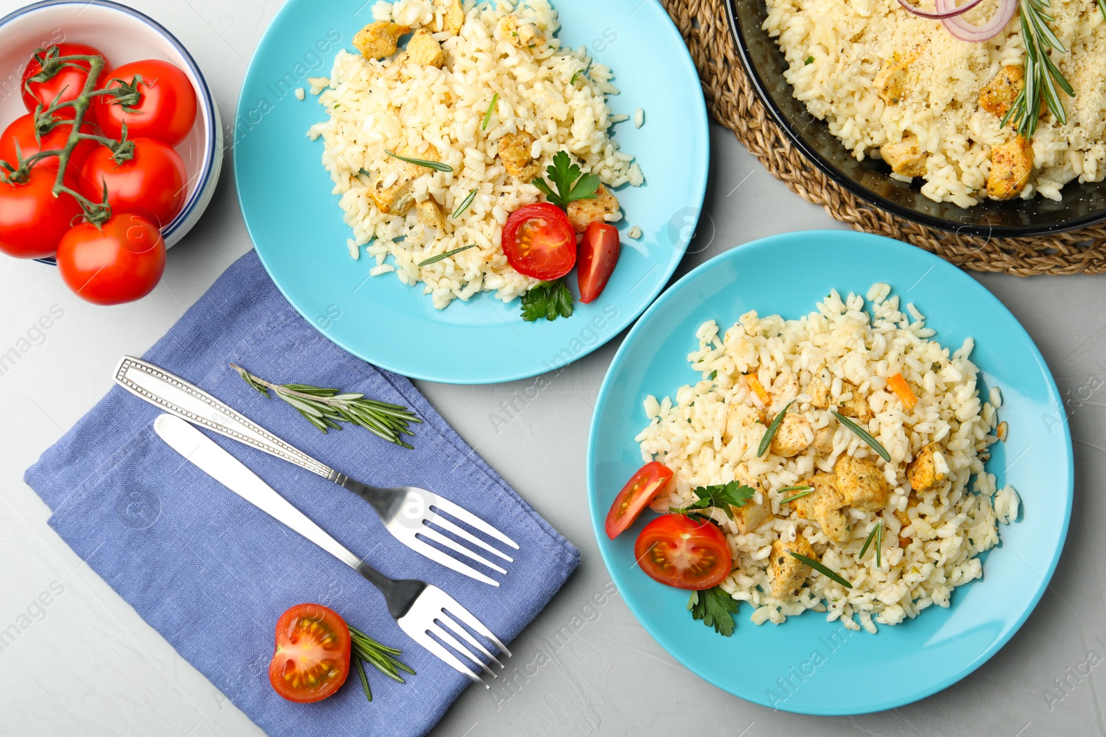 Photo of Delicious chicken risotto served on grey table, flat lay