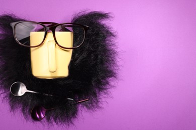 Photo of Man's face made of artificial beard, cup and glasses on purple background, top view. Space for text