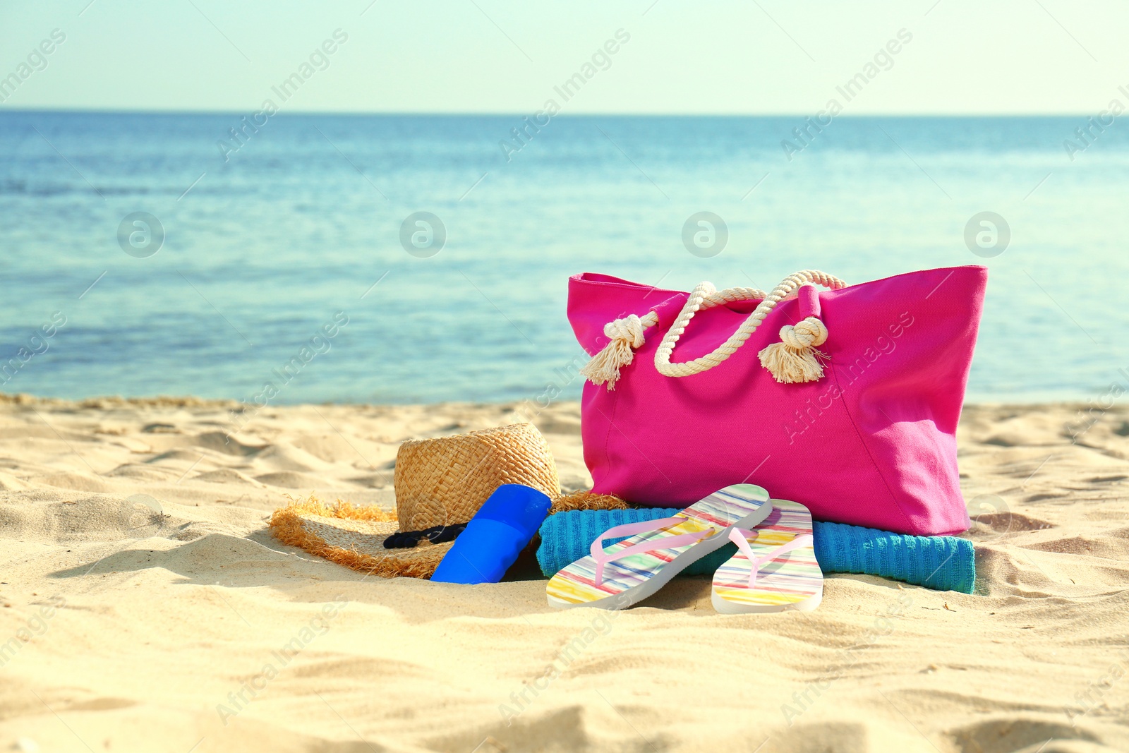 Photo of Composition with stylish beach accessories on sand near sea. Space for text