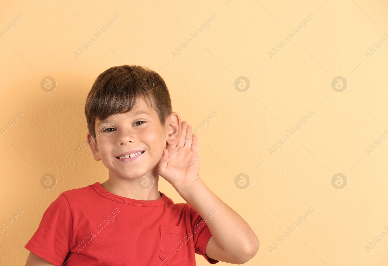 Photo of Cute little boy with hearing problem on color background. Space for text