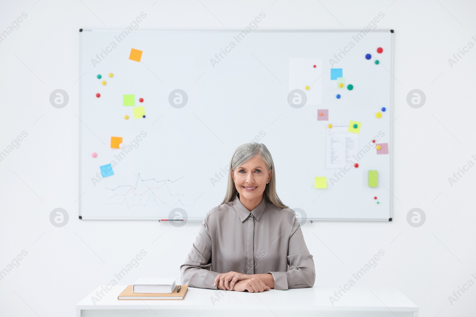 Photo of Portrait of professor sitting at desk in classroom