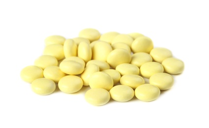 Pile of yellow pills on white background. Medical care and treatment