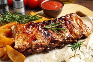 Photo of Delicious grilled ribs and garnish, closeup view