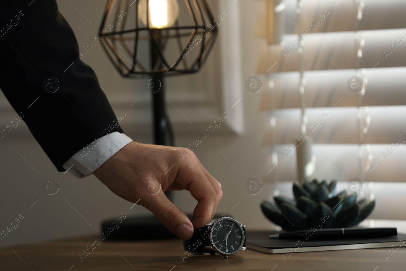 Photo of Man putting luxury wrist watch on table, closeup. Space for text