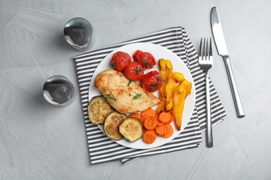 Photo of Delicious cooked chicken and vegetables served on grey table, flat lay. Healthy meals from air fryer