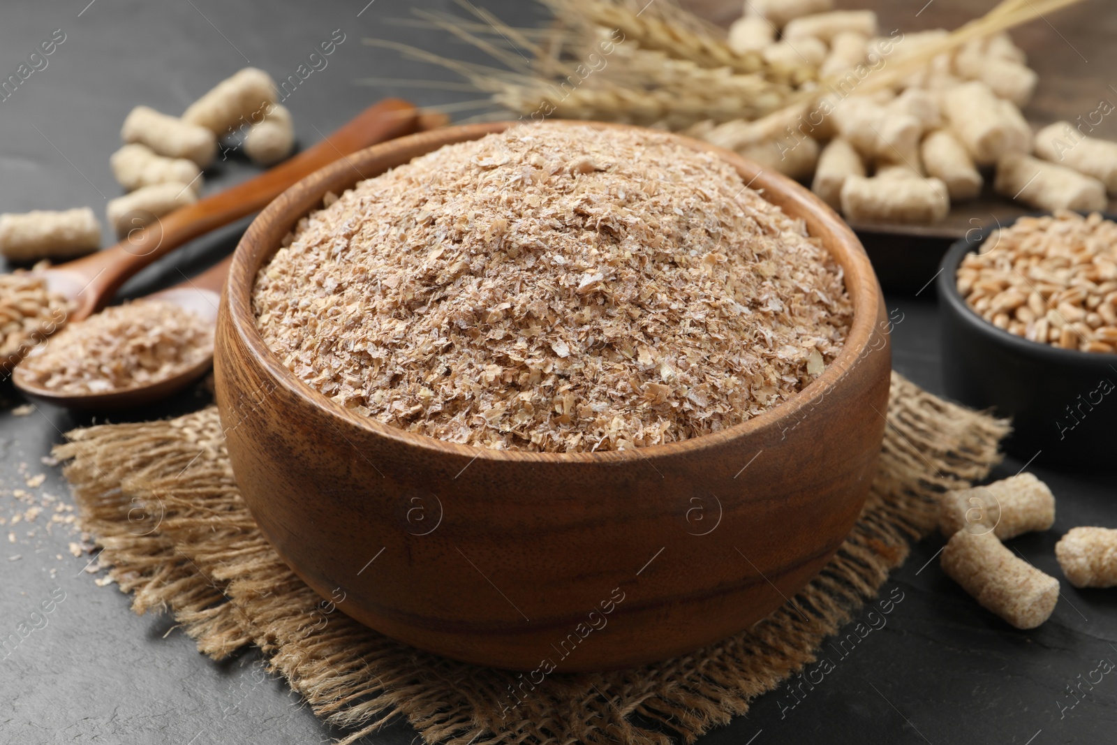Photo of Wheat bran in bowl on black table