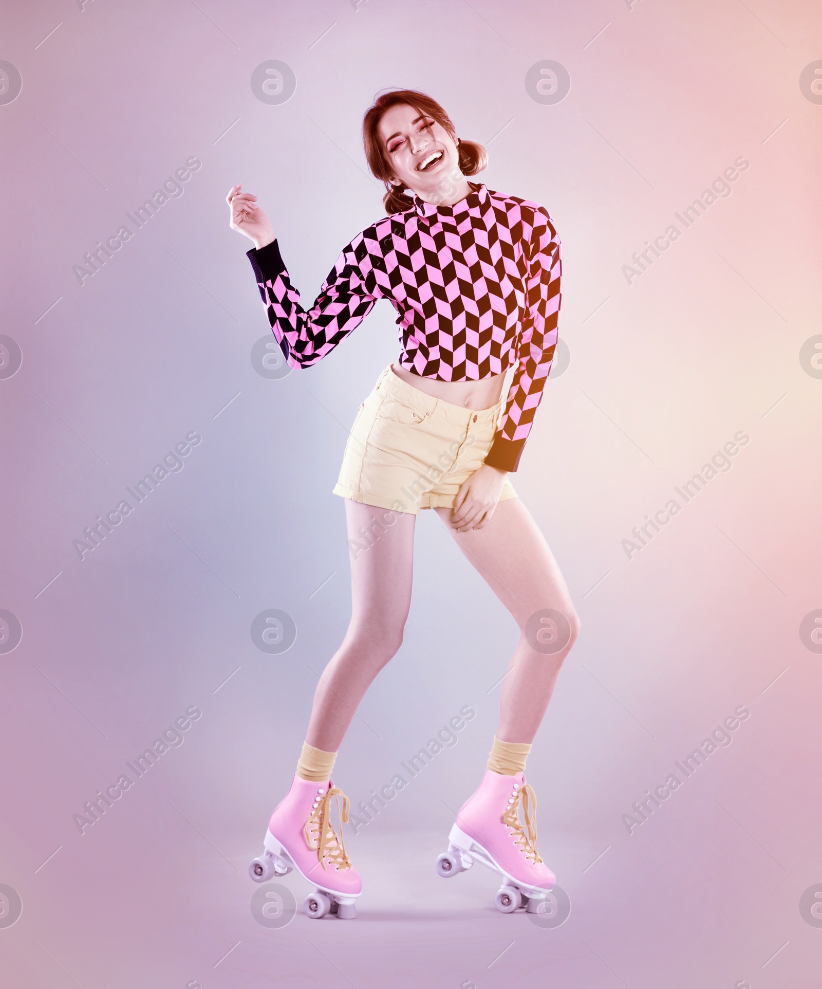 Image of Young woman with retro roller skates on color background