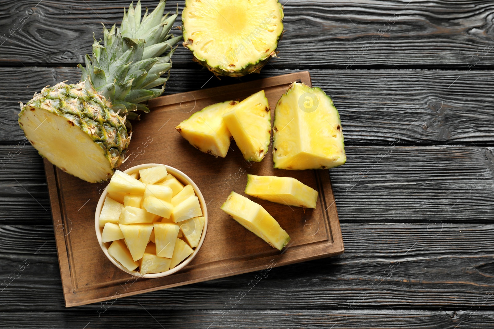 Photo of Wooden board with fresh sliced pineapple on table, top view