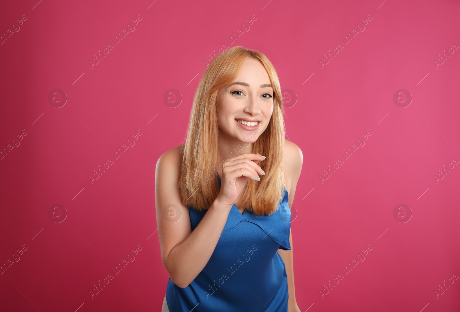 Photo of Beautiful young woman with blonde hair on pink background