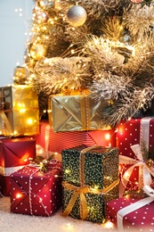 Photo of Many different gifts under Christmas tree indoors