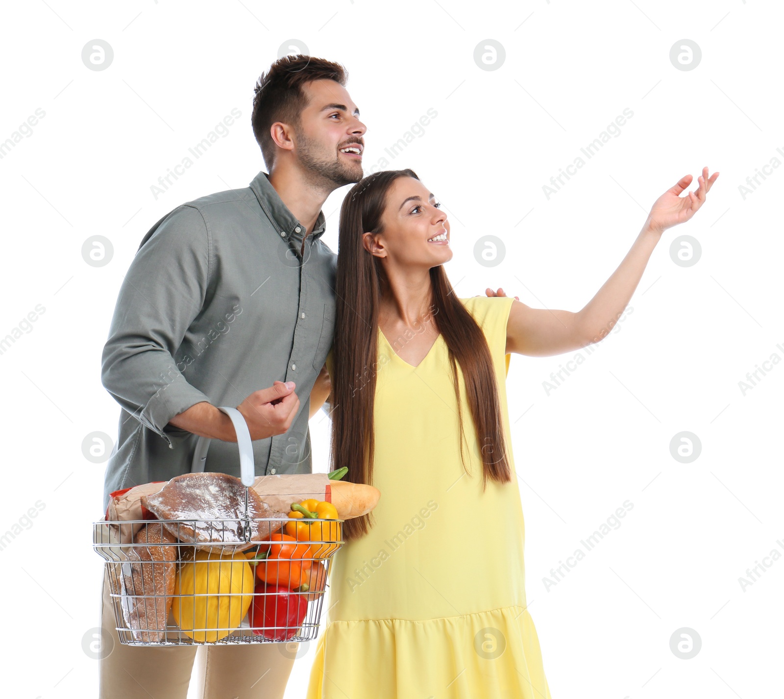 Photo of Young couple with shopping basket full of products isolated on white