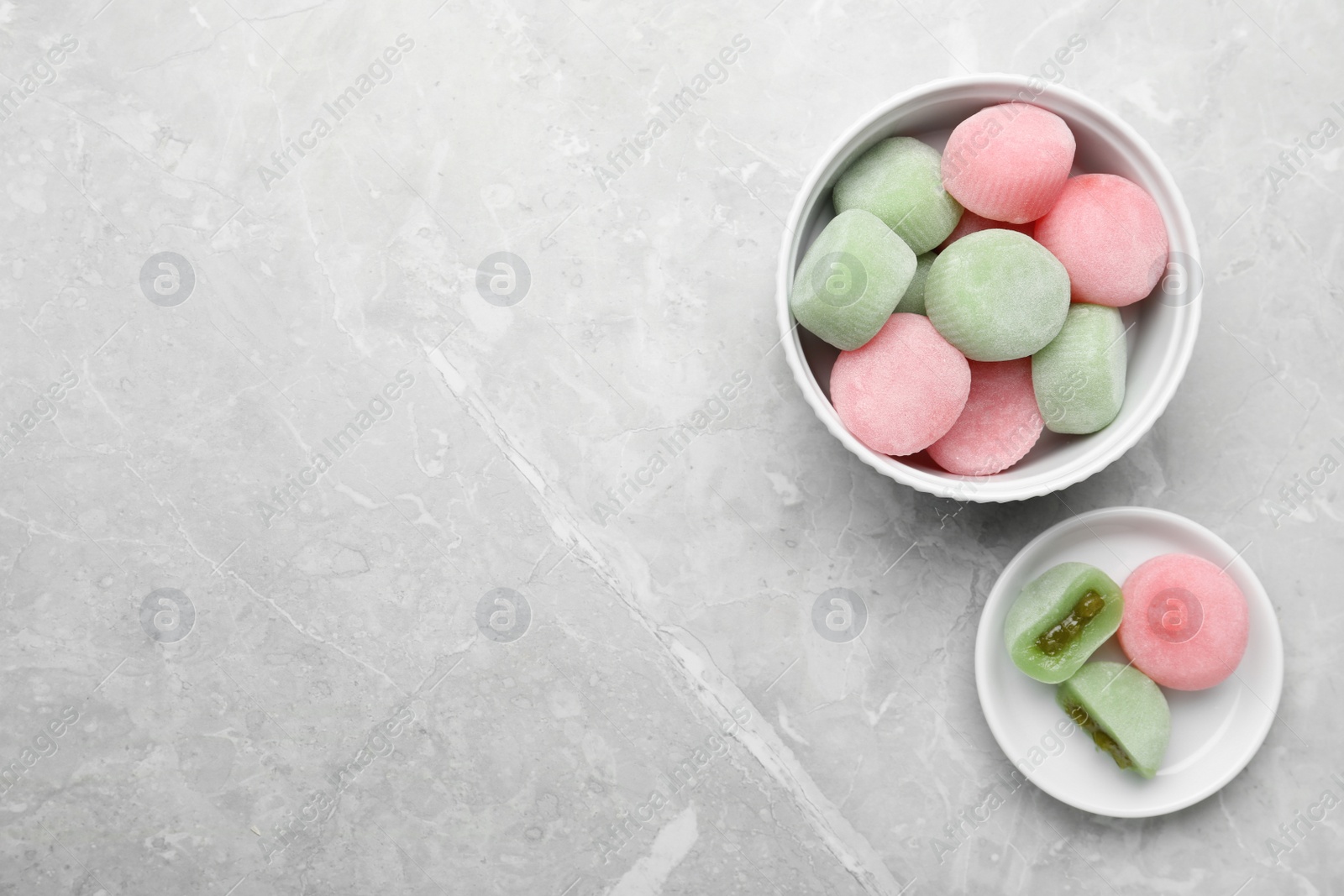 Photo of Delicious mochi on light grey marble table, flat lay with space for text. Traditional Japanese dessert