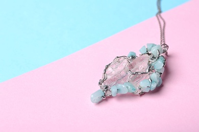 Photo of Beautiful silver pendent with pure quartz gemstones on color background. Space for text