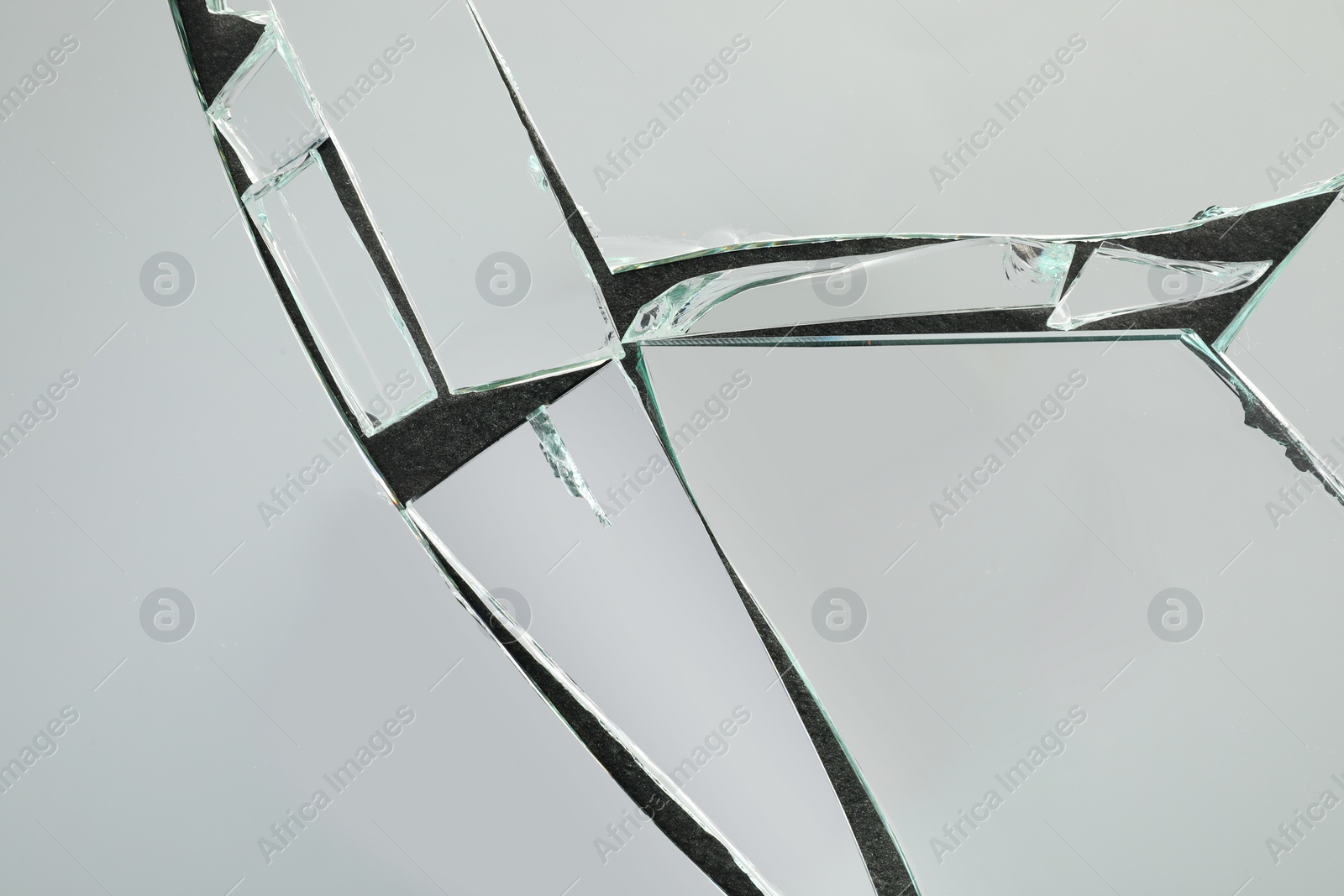 Photo of Shards of broken mirror on dark background, top view