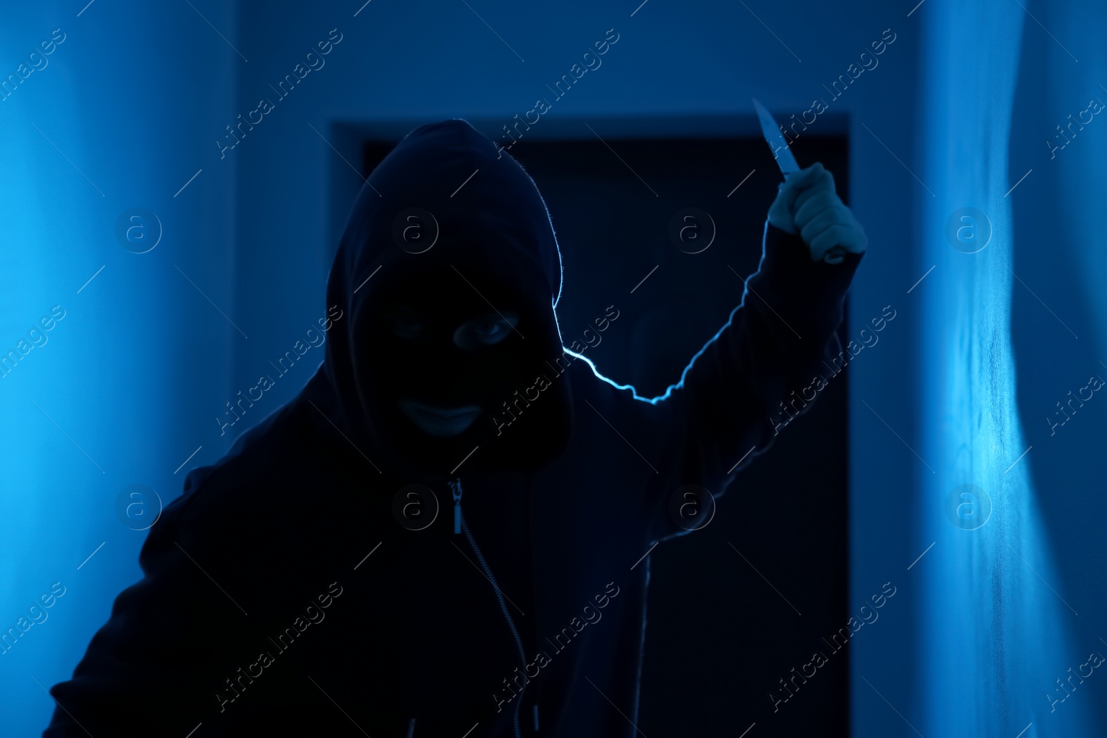 Photo of Man with knife in dark room. Dangerous criminal