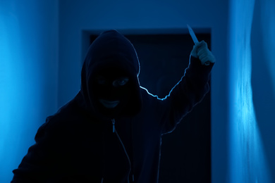 Man with knife in dark room. Dangerous criminal