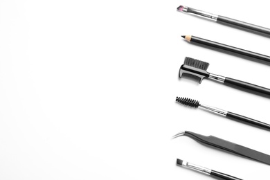 Set of professional eyebrow tools on white background, top view