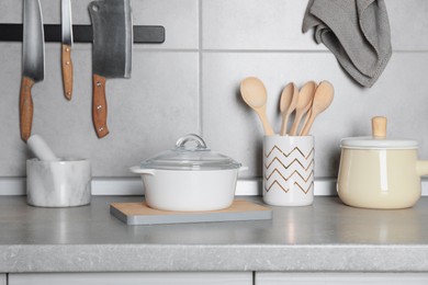 Photo of Set of cooking utensils and cookware on grey countertop