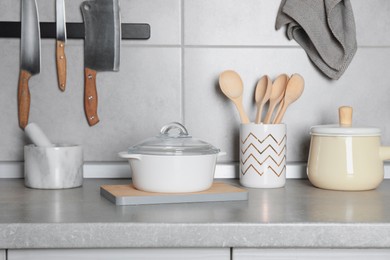 Set of cooking utensils and cookware on grey countertop