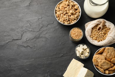 Different organic soy products on black table, flat lay. Space for text