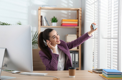 Lazy employee taking selfie at table in office