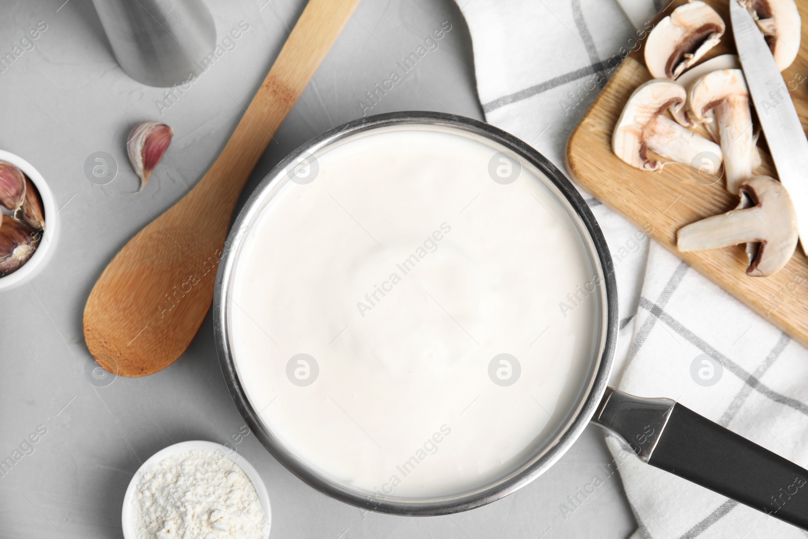 Photo of Flat lay composition with delicious creamy sauce on grey table