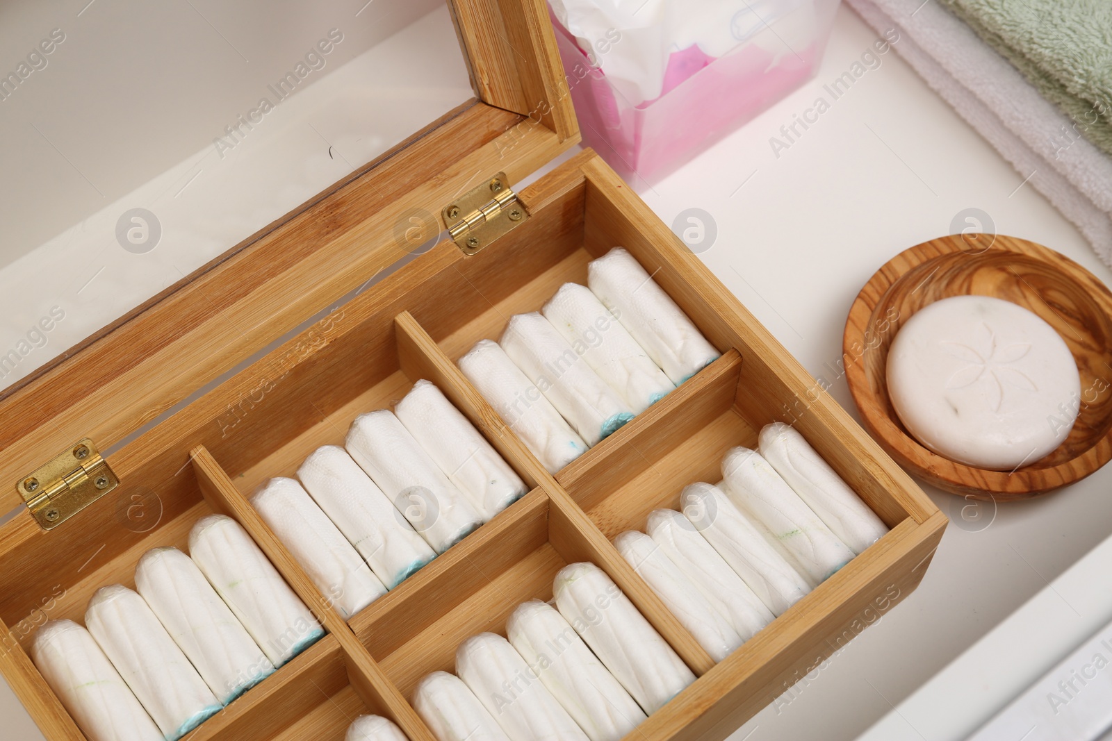 Photo of Storage of tampons and different hygiene products in white drawer, closeup