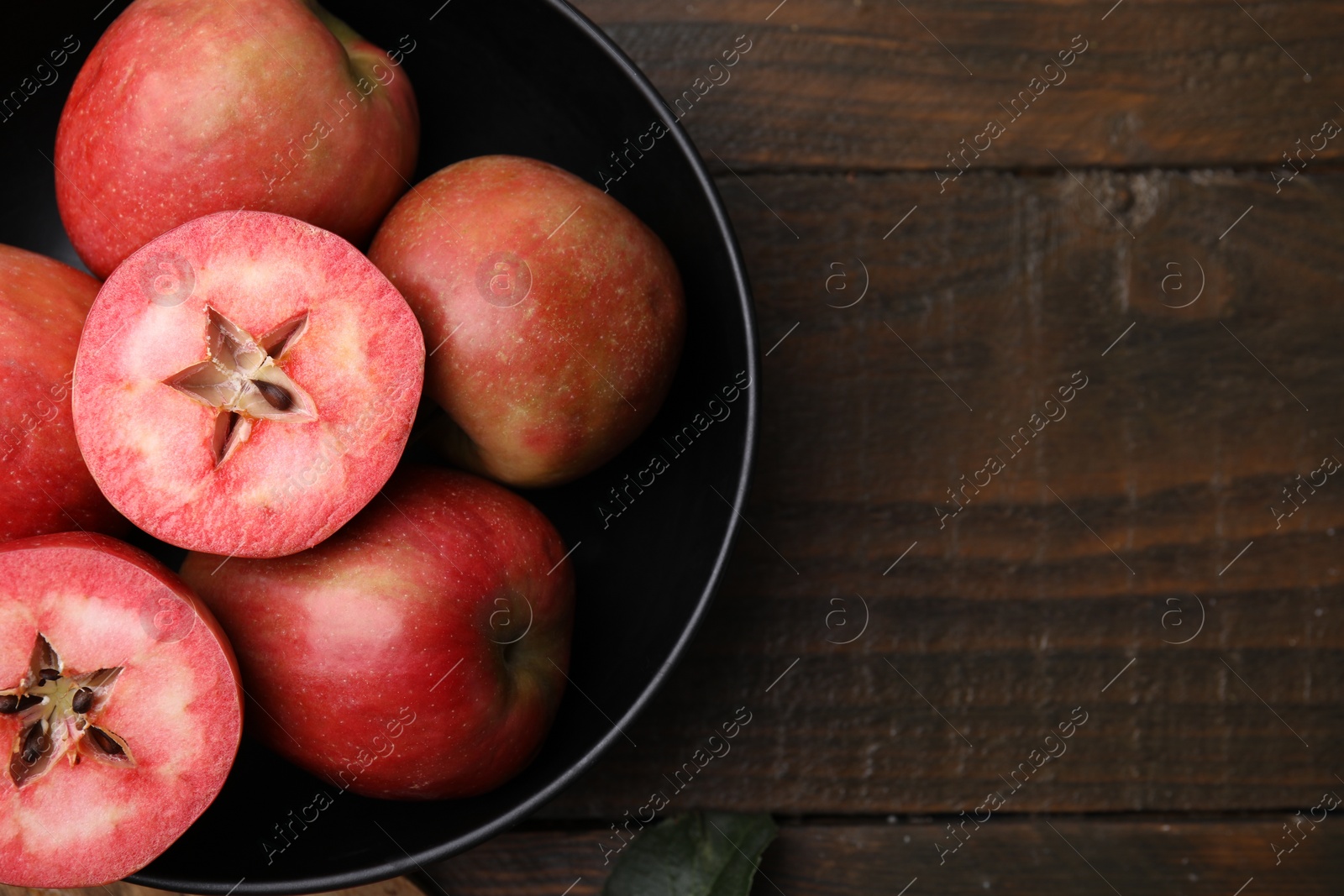 Photo of Tasty apples with red pulp on wooden table, top view. Space for text