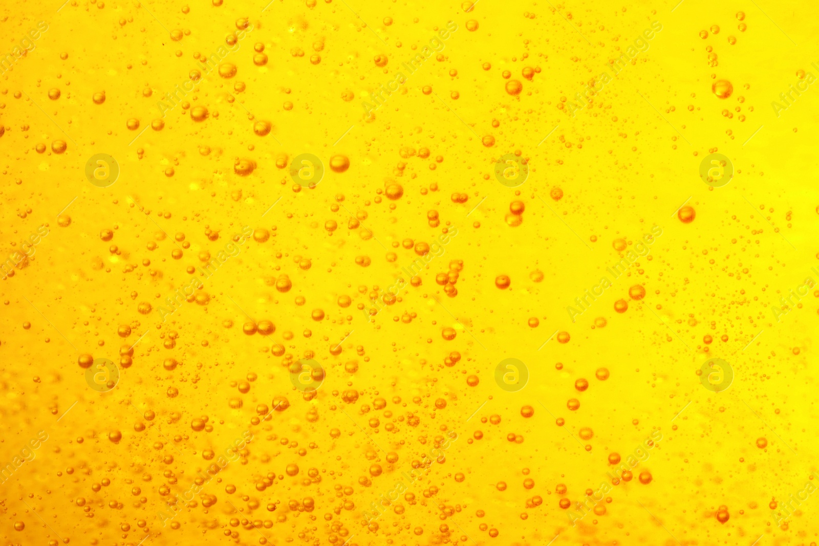 Photo of Tasty beer with bubbles as background, closeup