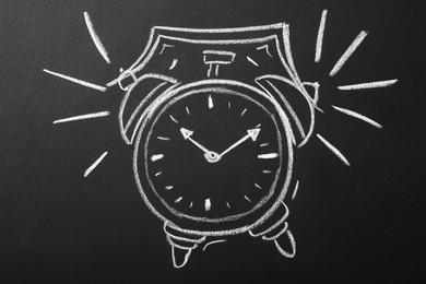 Photo of Drawn alarm clock on blackboard. School time