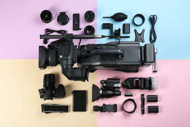 Flat lay composition with video camera and other equipment on color background