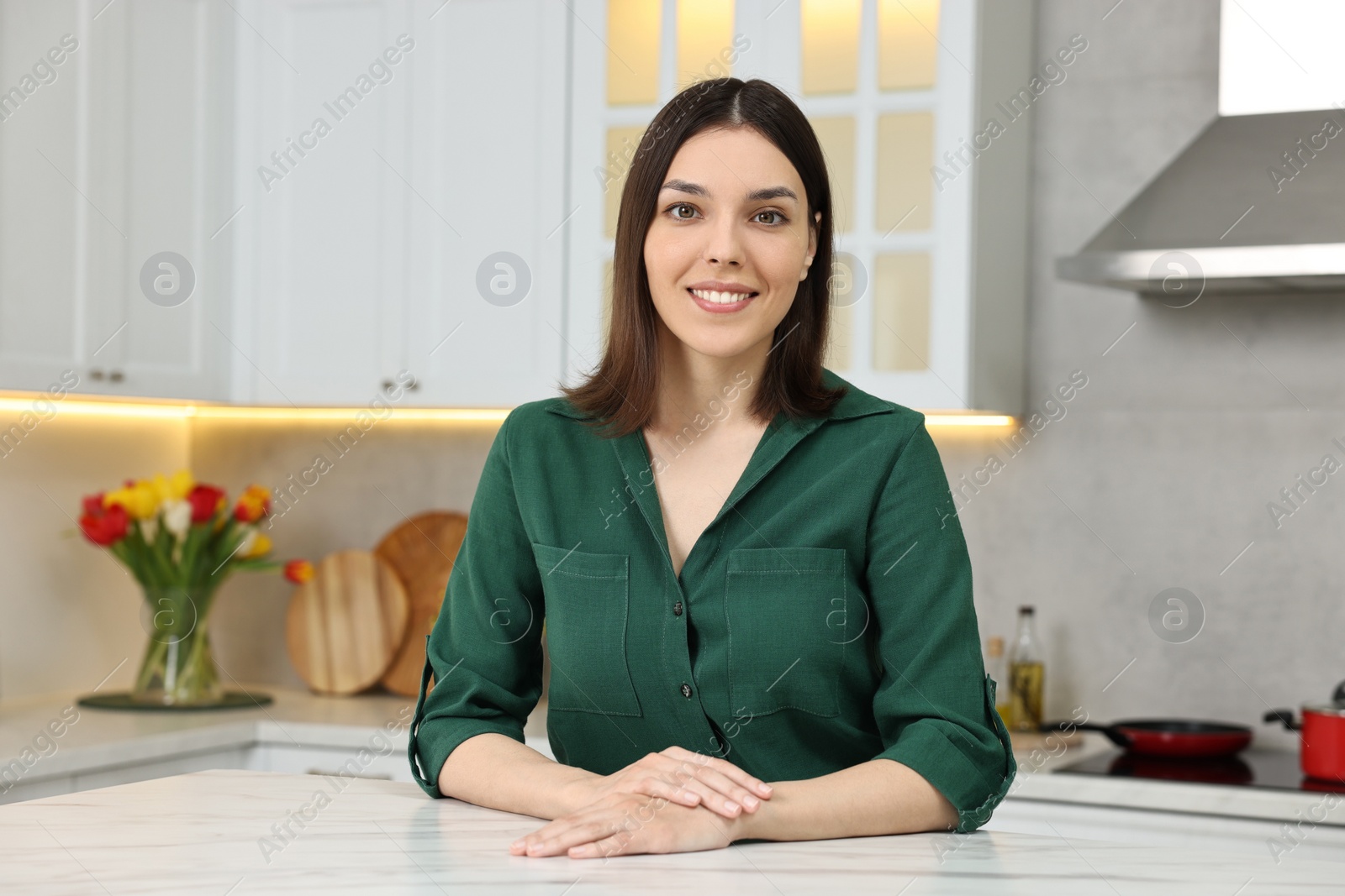 Photo of Portrait of beautiful young woman in kitchen