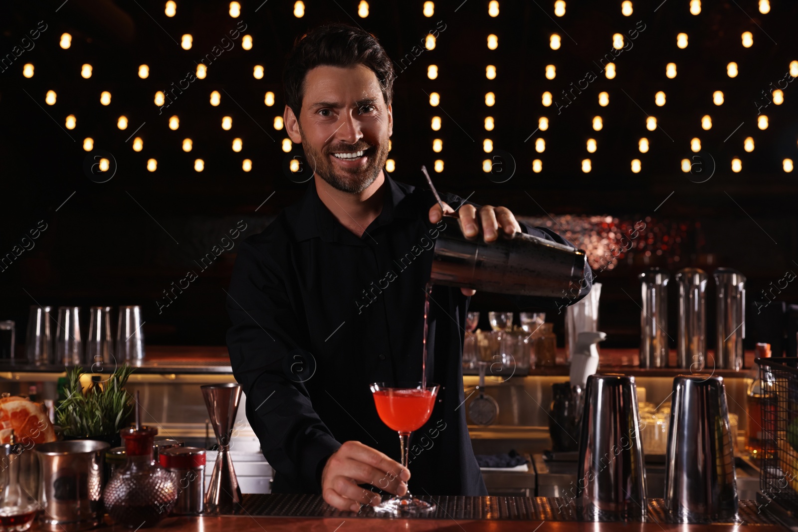 Photo of Bartender preparing fresh alcoholic cocktail in bar