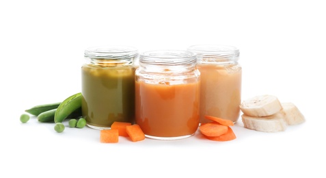 Jars with healthy baby food and ingredients on white background