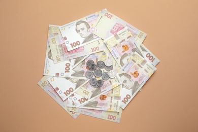 Photo of Ukrainian money on beige background, flat lay