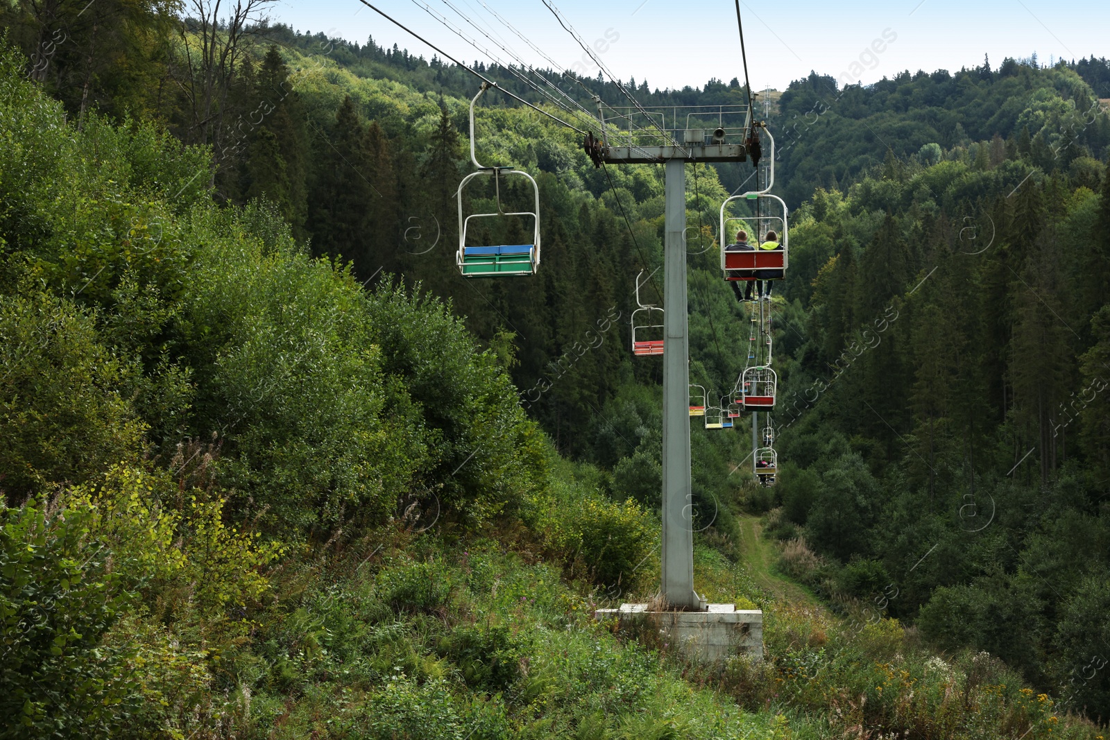 Photo of Ski lift and green trees at mountain resort