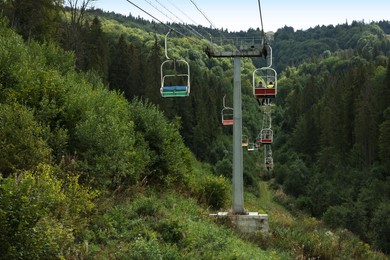 Ski lift and green trees at mountain resort