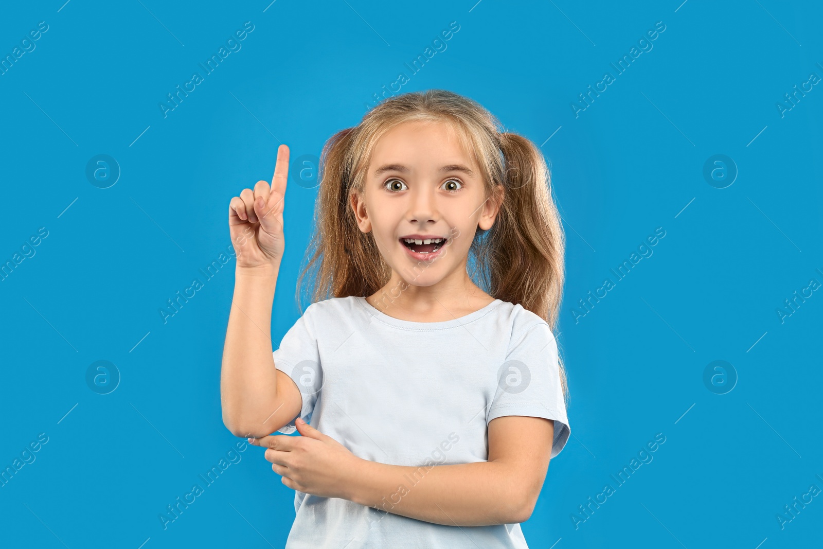 Photo of Cute little girl posing on blue background