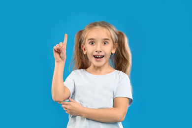 Cute little girl posing on blue background