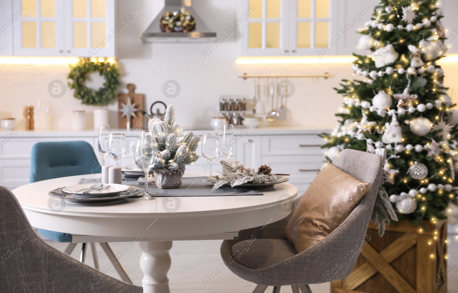 Photo of Table with set of dishware and beautiful Christmas decor in kitchen interior