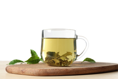 Tasty hot green tea on wooden table against white background