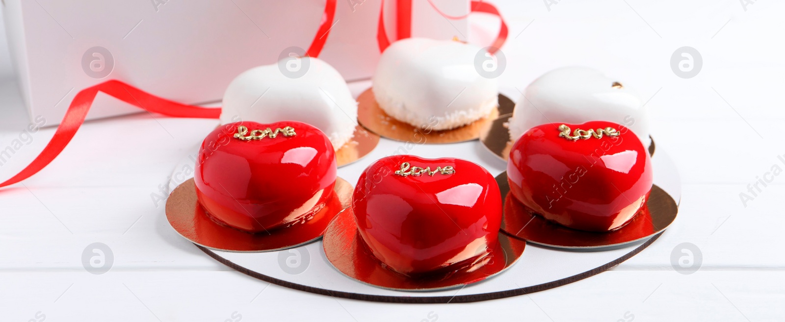 Photo of St. Valentine's Day. Delicious heart shaped cakes on white wooden table