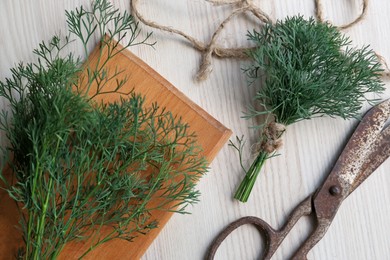 Photo of Flat lay composition with dill, cutting board and rusty scissors on white wooden table