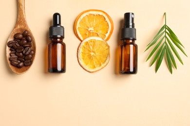 Bottles of organic cosmetic products, coffee beans, dried orange slices and green leaf on beige background, flat lay. Space for text
