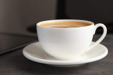 Photo of Cup of americano on grey table in office, closeup. Coffee Break